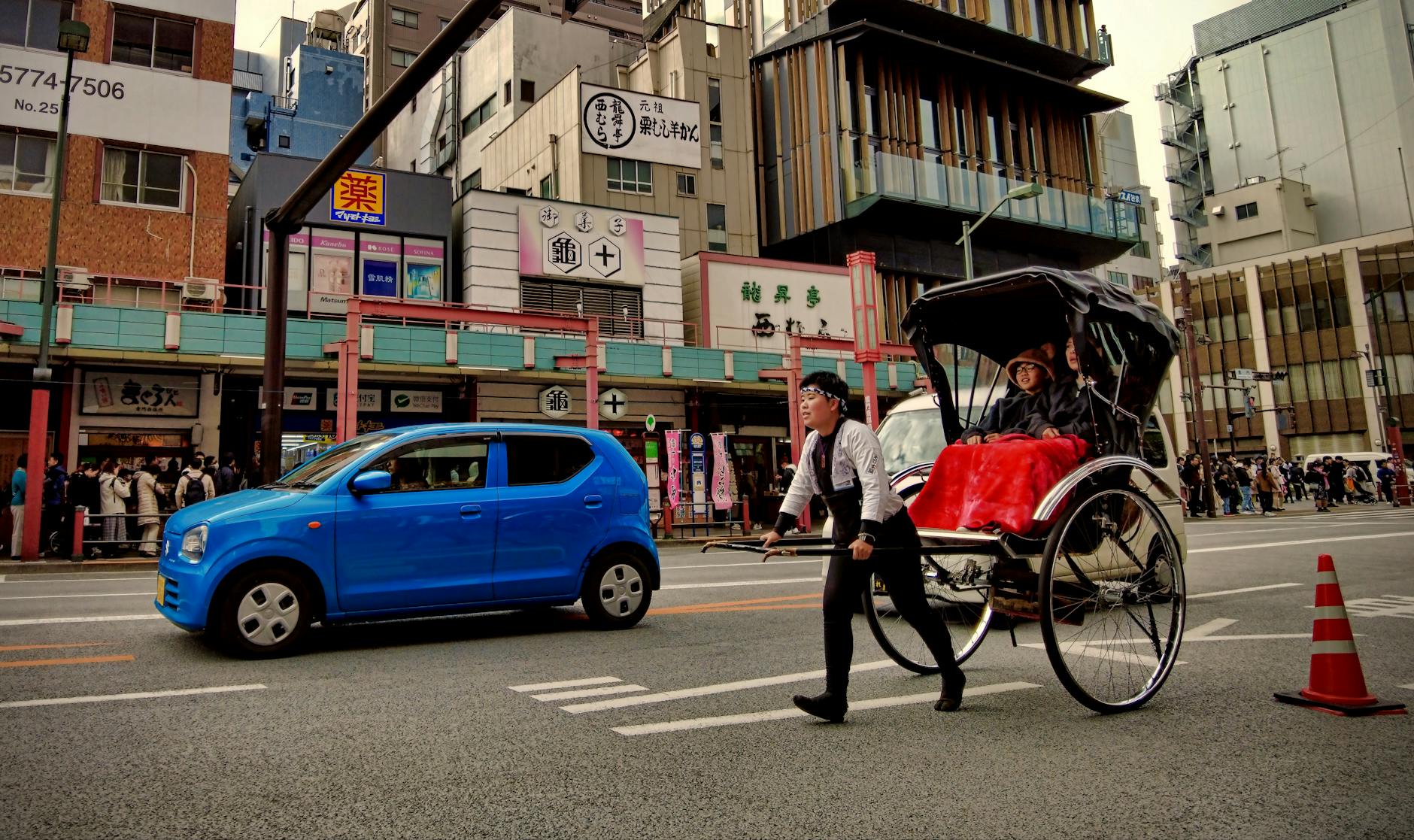 A rickshaw pulls tourists through Asakusa, Tokyo, blending tradition with modern city life.