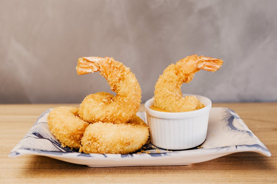 Golden crispy tempura shrimp beautifully plated on ceramic dish at a Tokyo restaurant