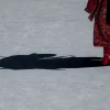 Shadow of a Japanese performer in traditional attire on a sunny day in Buenos Aires.