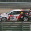 Action shot of a fast race car speeding on a Taiwan racetrack, blurred background conveying speed.