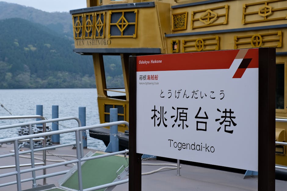 Signage at Togendai-ko Port with Ashinoko Lake and sightseeing cruise ship.