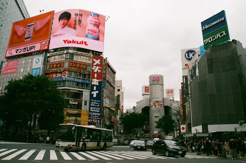 Vibrant cityscape of Shibuya Crossing, Tokyo, showcasing urban life and iconic billboards.