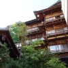 Wooden architecture of a traditional ryokan in Yamanouchi, Nagano, Japan amidst greenery.