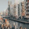 Vibrant cityscape of Kyoto's canal area with pedestrians and colorful buildings showcasing urban life.