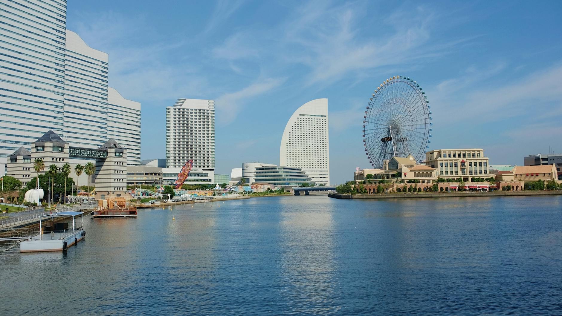 Yokohama skyline featuring Cosmo Clock 21 Ferris wheel under a bright blue sky.