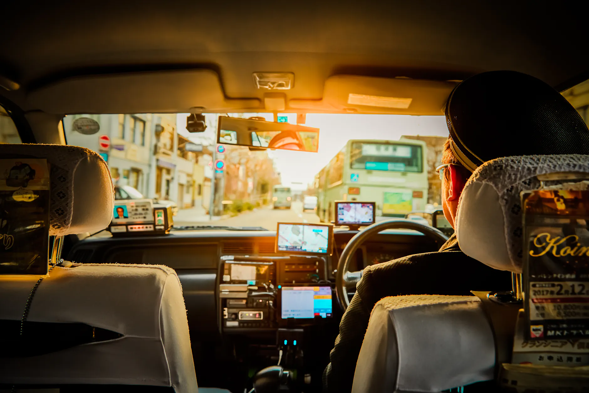 Experience a scenic ride through Kyoto in a traditional taxi, capturing urban life during sunset.