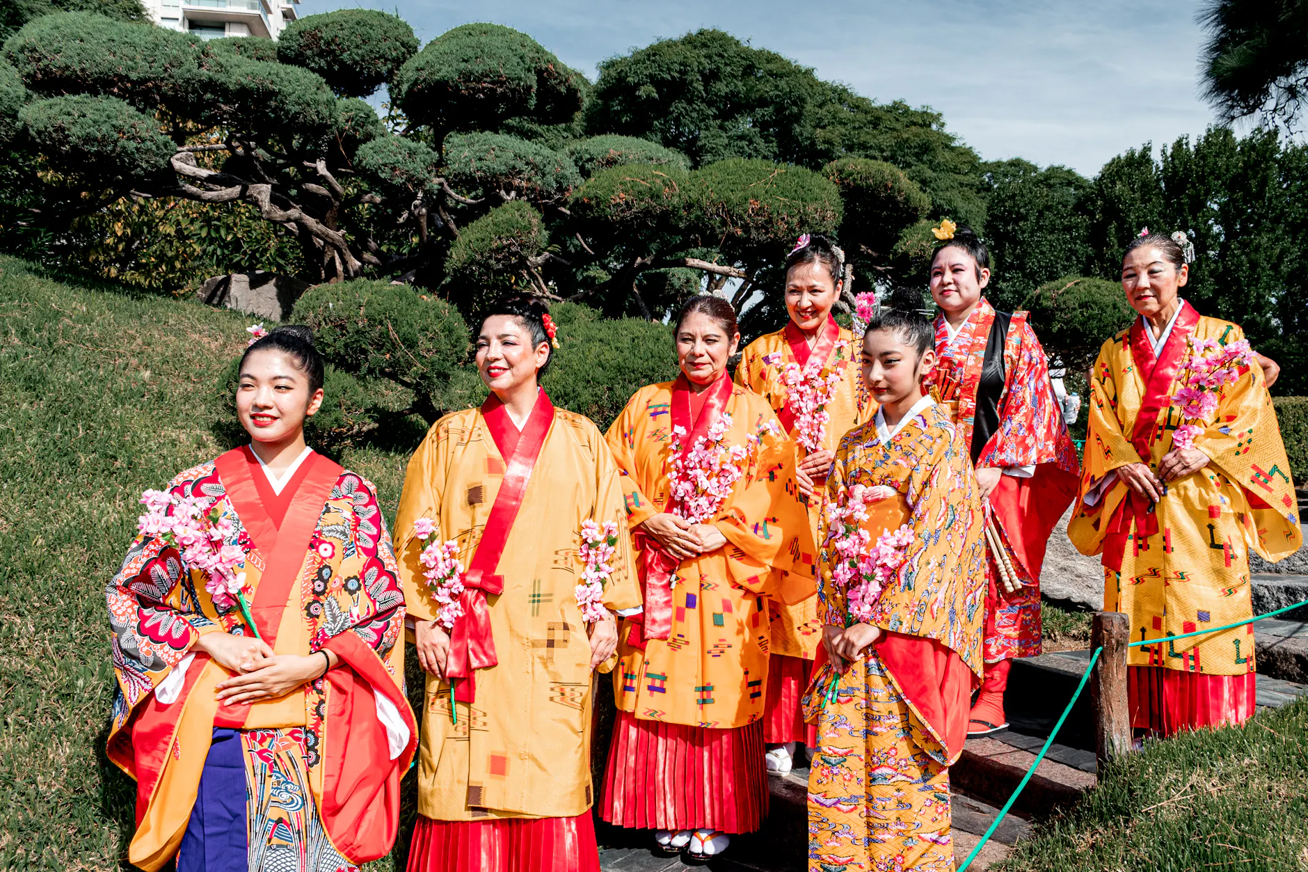 Group of women in vibrant kimonos celebrating Japanese culture in Buenos Aires garden.