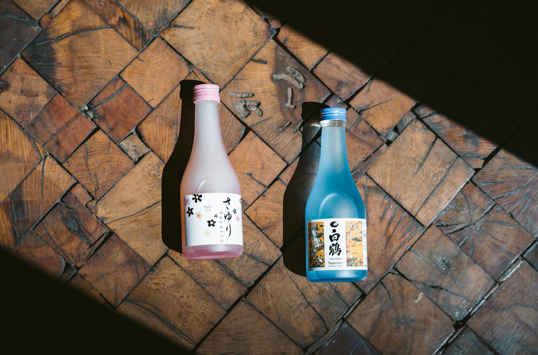 Japanese sake bottles on wooden floor with shadows