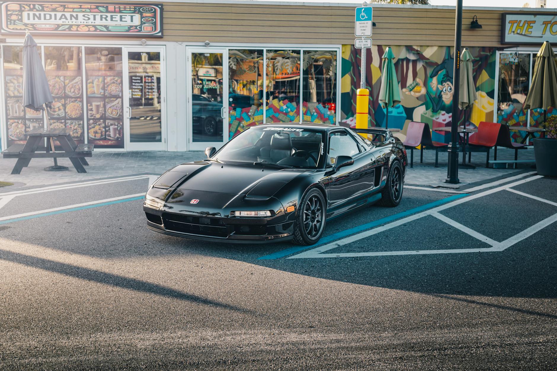 A sleek black Honda NSX parked in front of colorful street art in Tampa, Florida. — Photo by Bradikan Cars on Pexels
