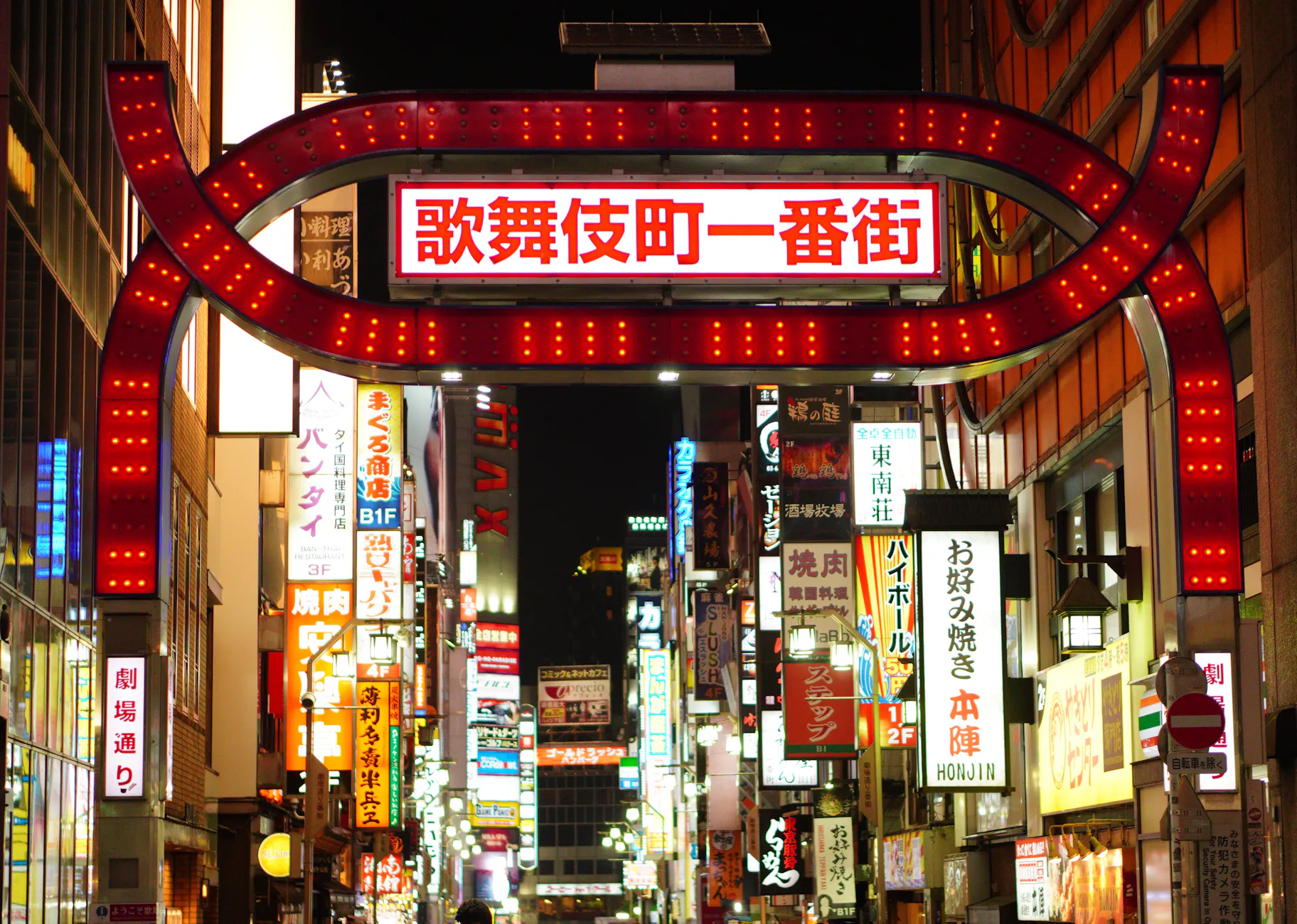 Illuminated streets of Shinjuku, Tokyo showcasing vibrant nightlife and neon signs.
