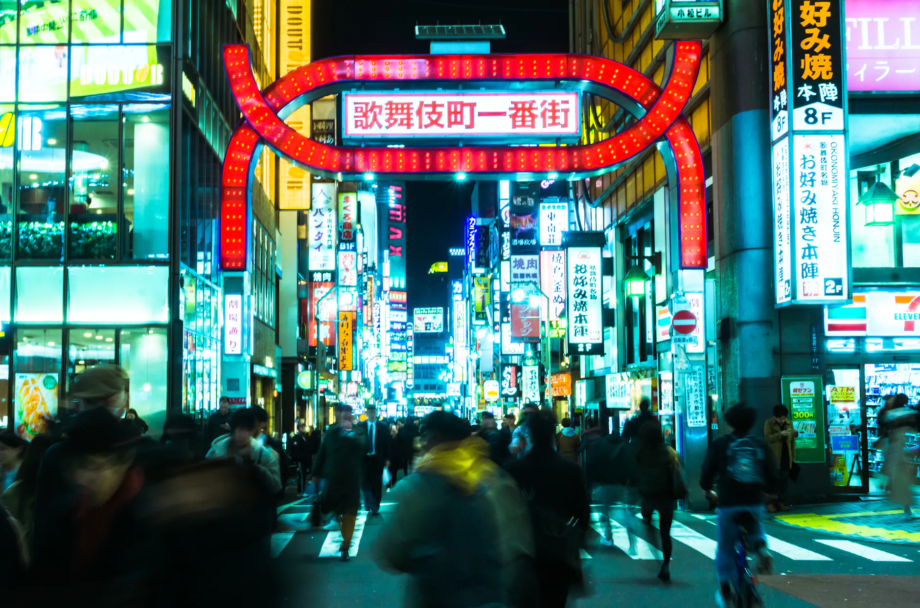 Explore the bustling streets of Shinjuku, Tokyo at night, alive with neon lights and crowds.