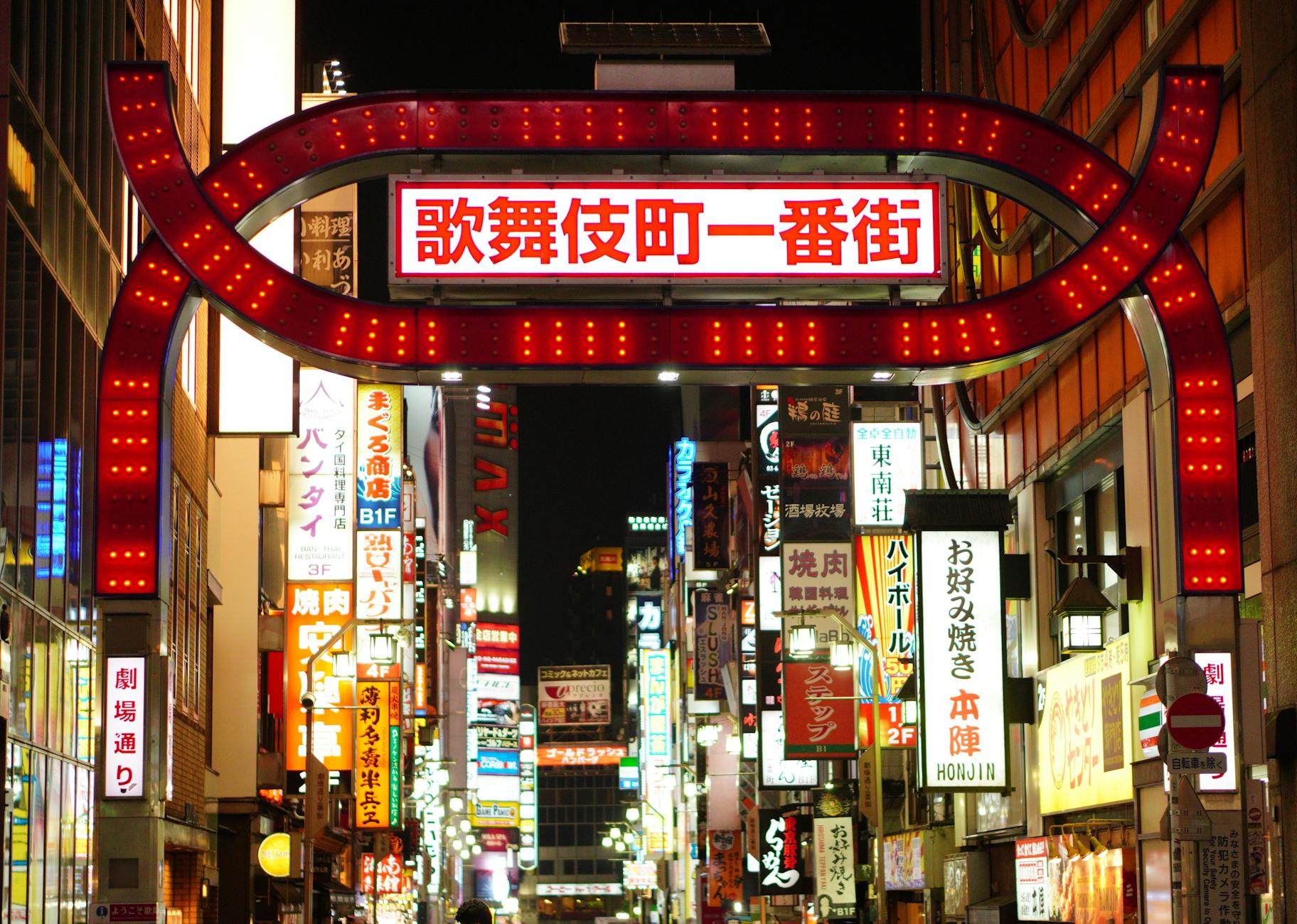 Illuminated streets of Shinjuku, Tokyo showcasing vibrant nightlife and neon signs.