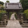 Explore the serene pathway leading to a traditional Japanese gate at Kencho-Ji Temple in Kamakura.
