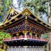 A beautifully ornate Japanese temple amongst towering trees in Nikko, Japan.