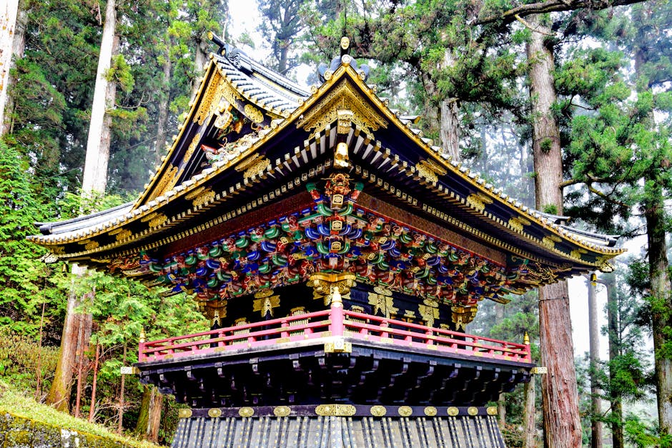 A beautifully ornate Japanese temple amongst towering trees in Nikko, Japan.