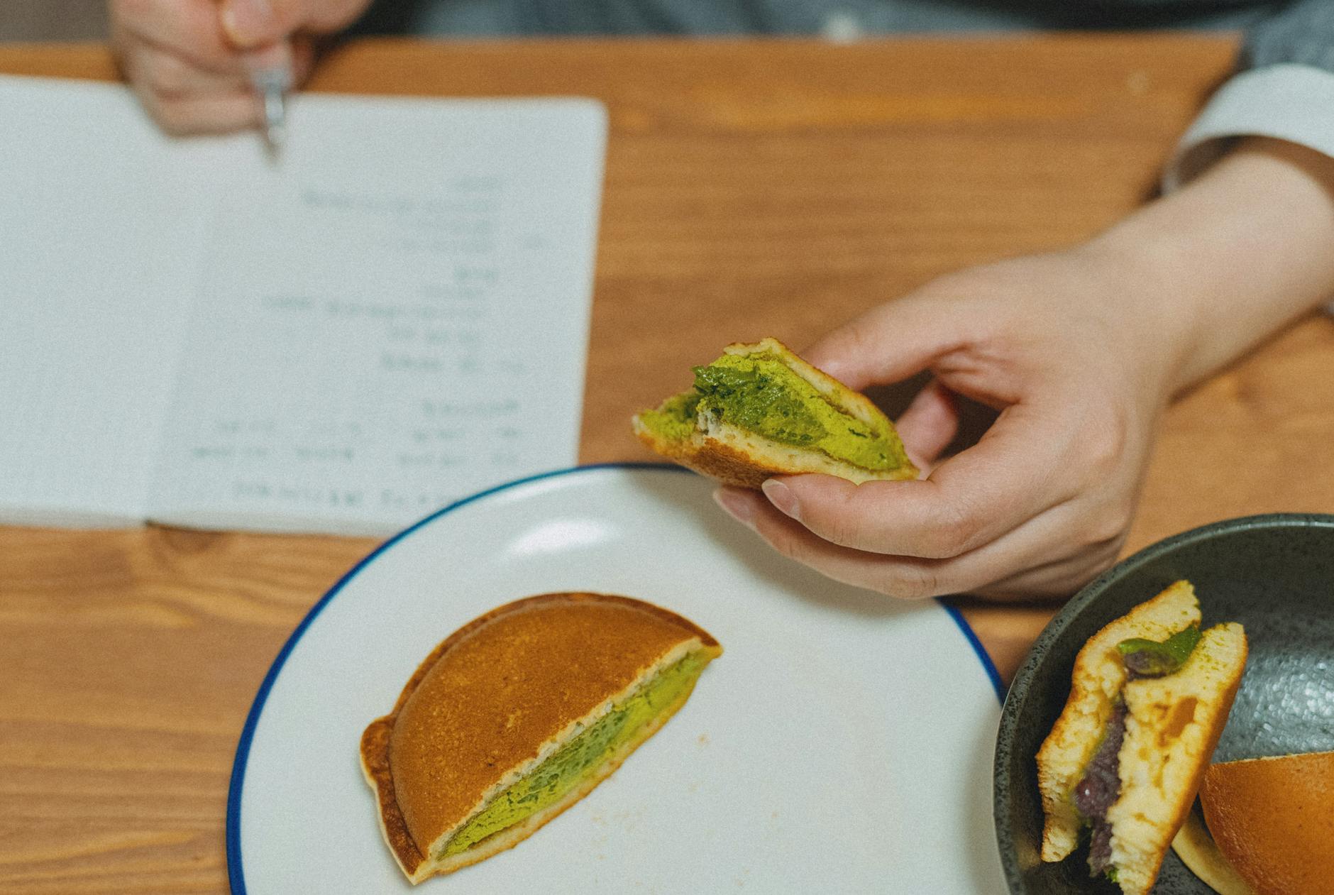 Close-up of dorayaki pancakes filled with matcha and red bean, shot indoors.