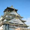Stunning view of Osaka Castle in Japan against a clear blue sky, highlighting its historical architecture.