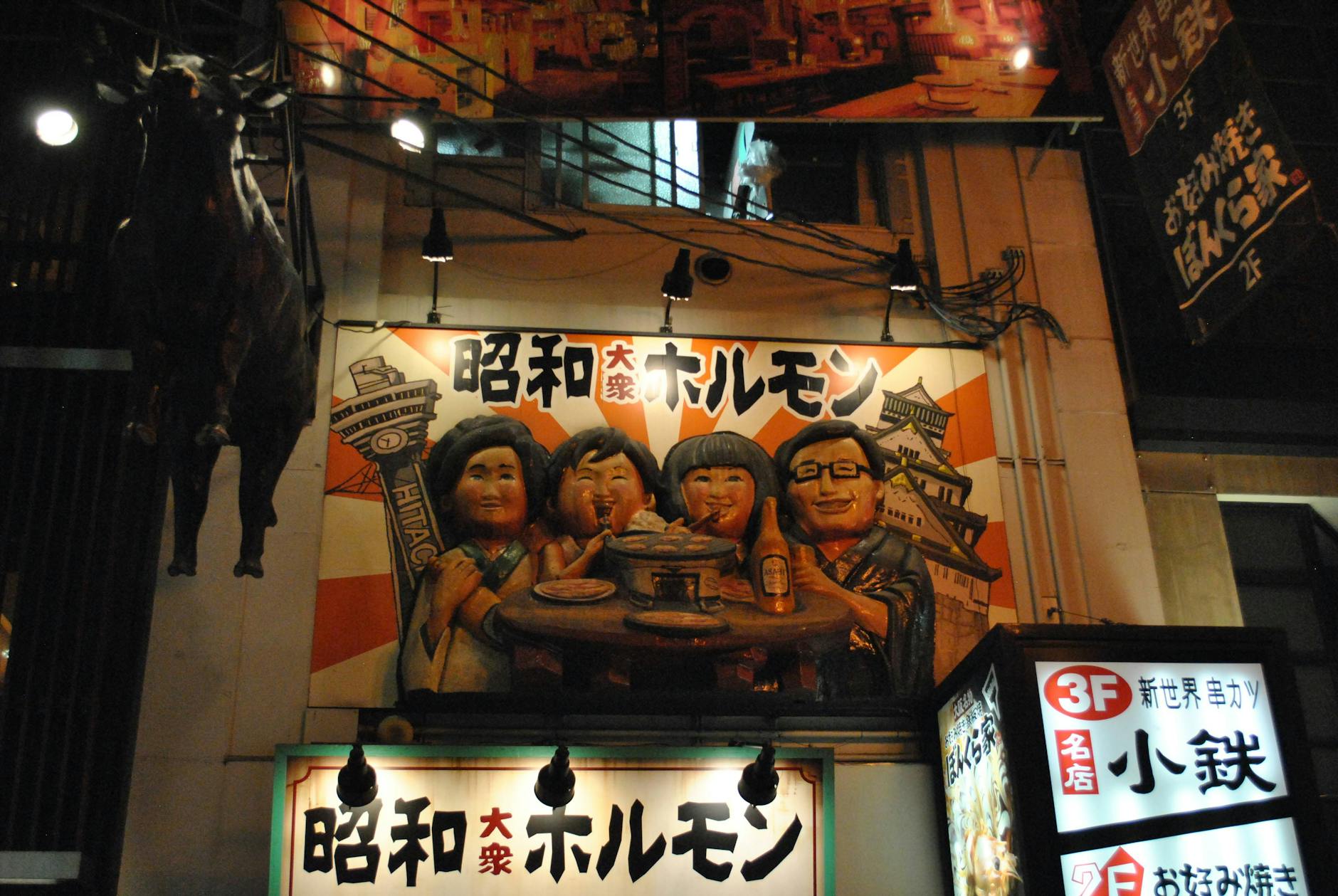 Colorful signs and sculptures in a lively night setting, capturing urban culture.