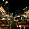 Vibrant night scene in Kyoto featuring busy streets and iconic Japanese taxis.