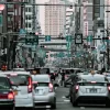 A bustling urban street in Osaka, Japan with heavy traffic and cityscape buildings in view.