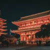 Illuminated Senso-ji Temple in Tokyo at night, showcasing traditional Japanese architecture.