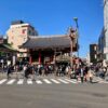 Crowds flock to the iconic Kaminarimon Gate in Asakusa, Tokyo on a sunny day, creating a vibrant street scene.