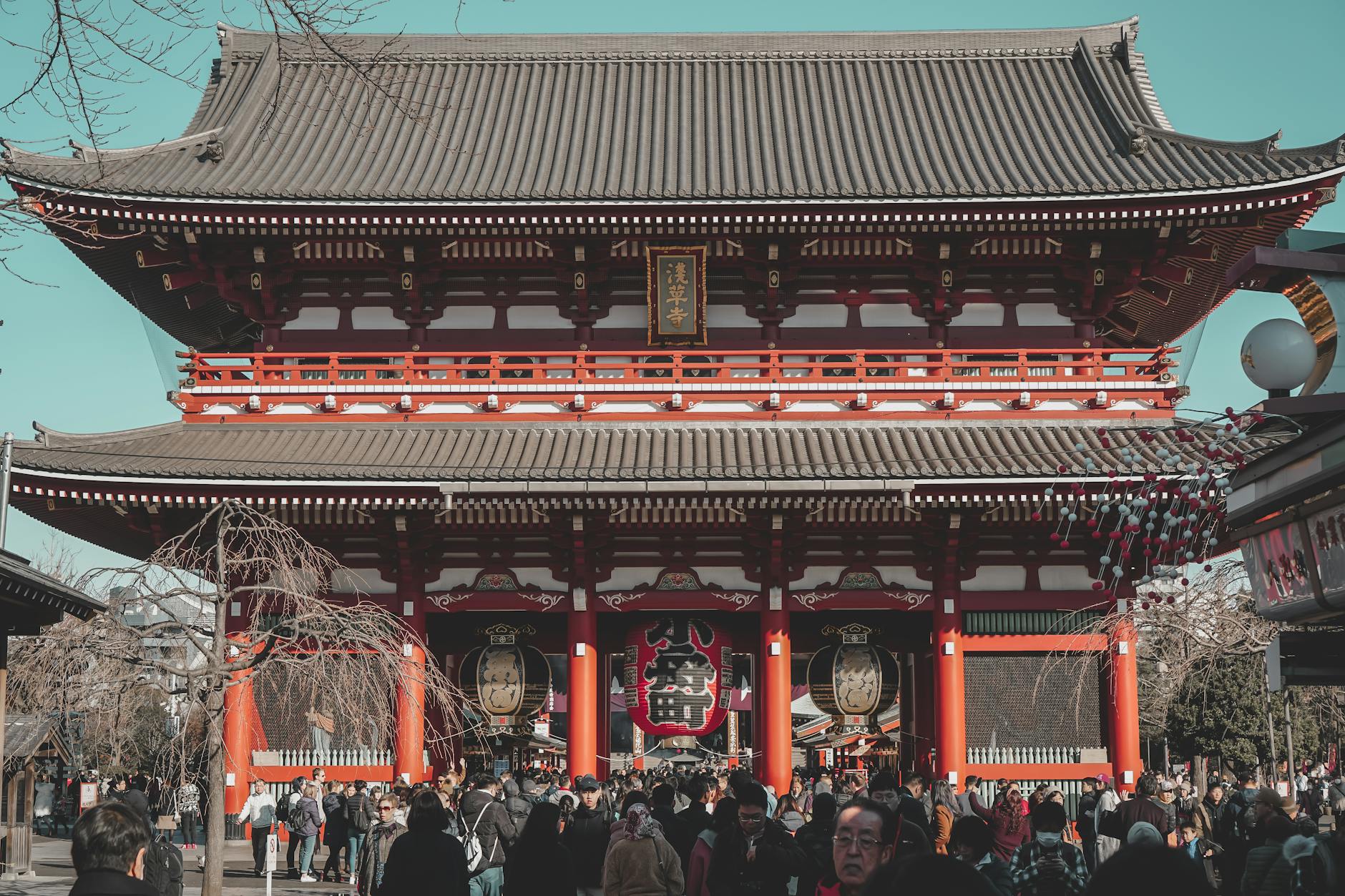 Sensō-ji Temple in Tokyo with visitors in the foreground, showcasing traditional Buddhist architecture.