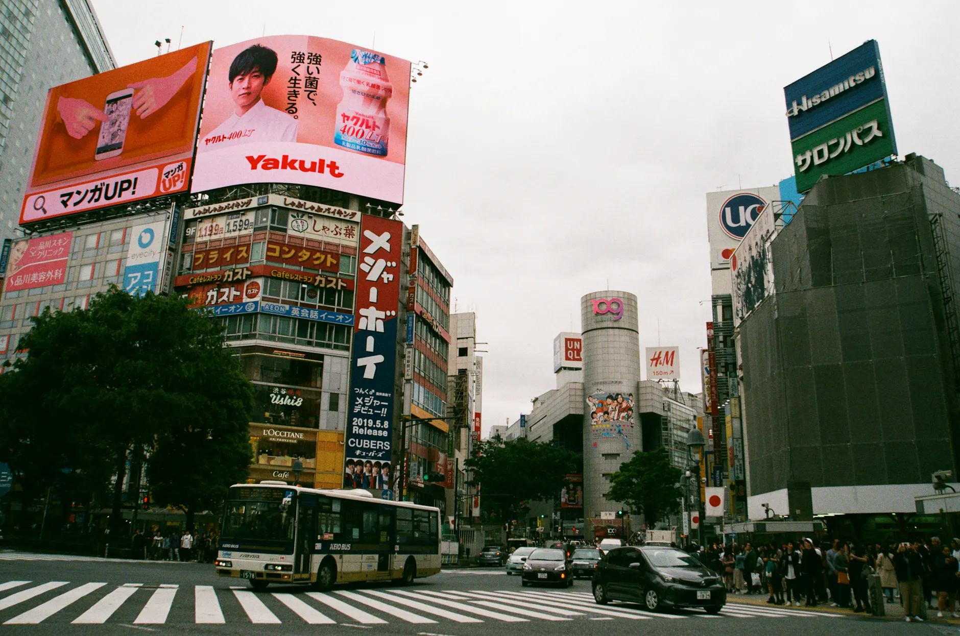 Vibrant cityscape of Shibuya Crossing, Tokyo, showcasing urban life and iconic billboards.