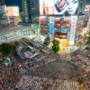 Shibuya Scramble Crossing in Tokyo teems with life, illuminated by vibrant city lights at night.