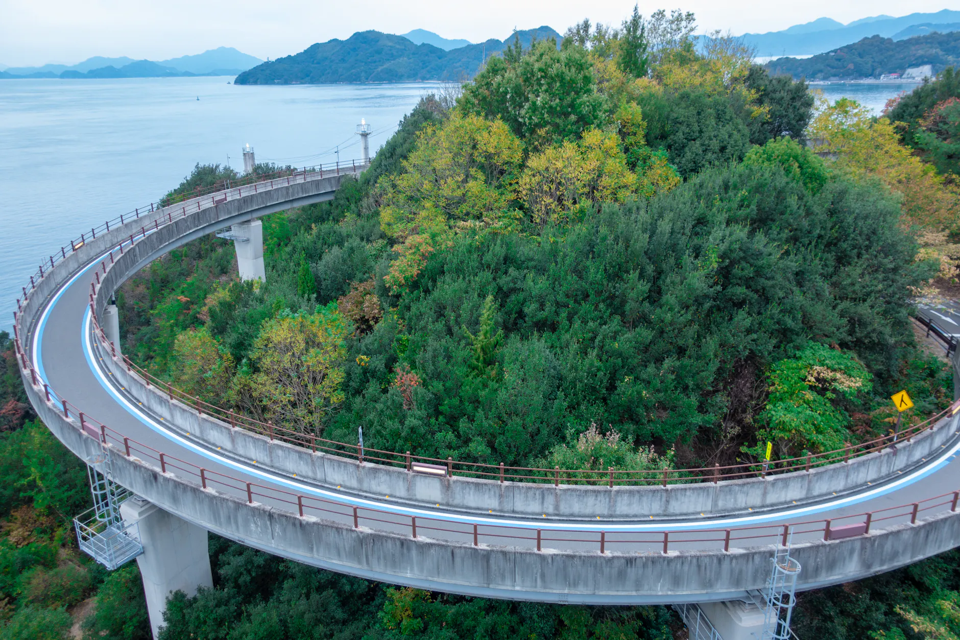 Aerial view of the scenic winding road in Onomichi, Japan surrounded by lush greenery.