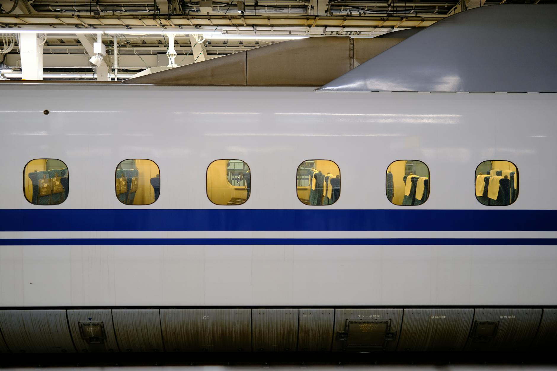 View of the interior of a Shinkansen bullet train through windows at Tokyo Station, Japan.