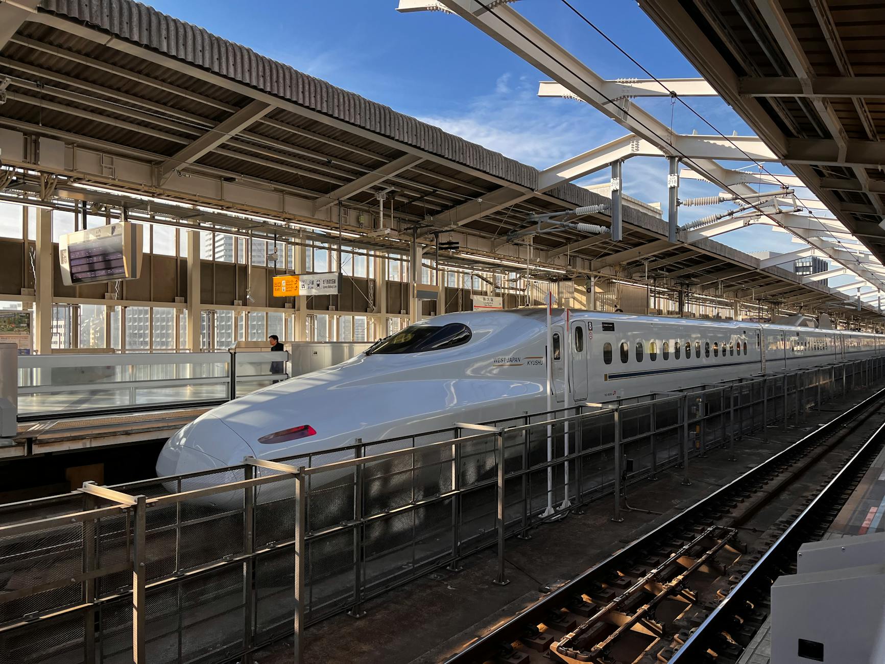 High-speed Shinkansen bullet train at the platform in Osaka, Japan, during daytime.