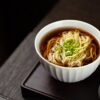 Authentic soba noodles in savory dashi broth garnished with green onions - traditional Japanese soba restaurant Tokyo
