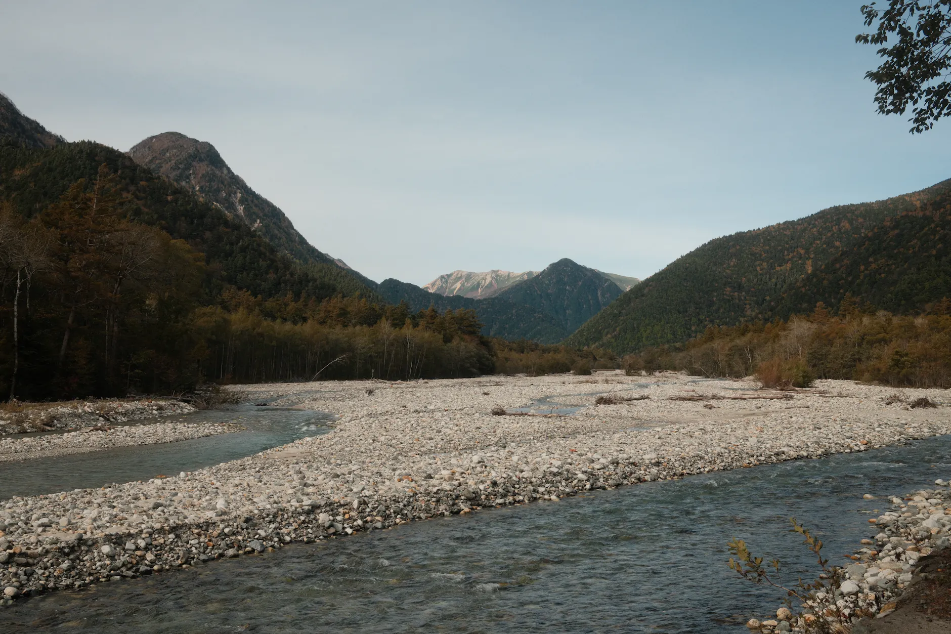 A tranquil mountain river flowing through the scenic Kamikochi valley in Matsumoto, Japan.