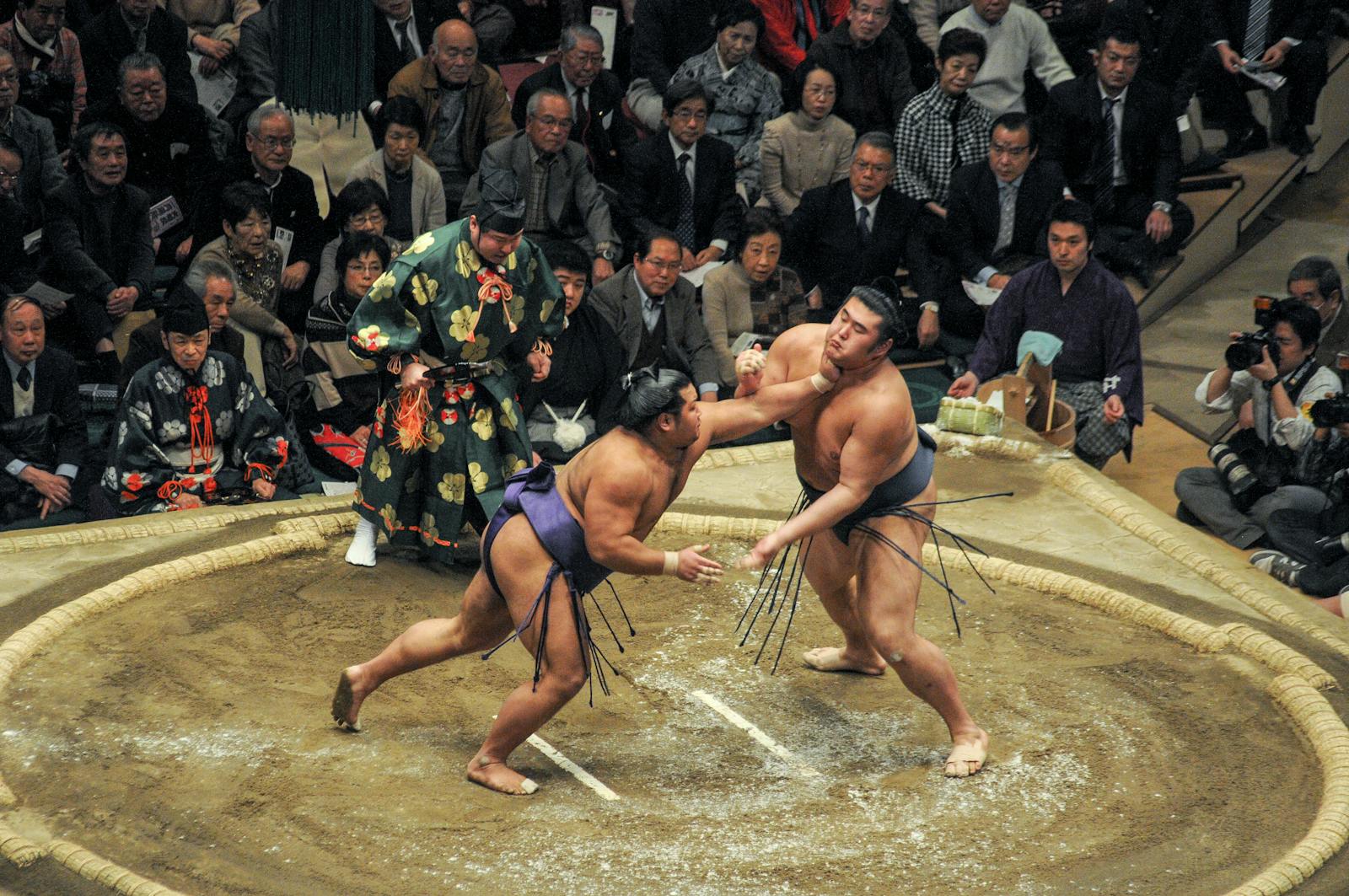 Sumo wrestlers compete in a traditional match inside a Tokyo arena