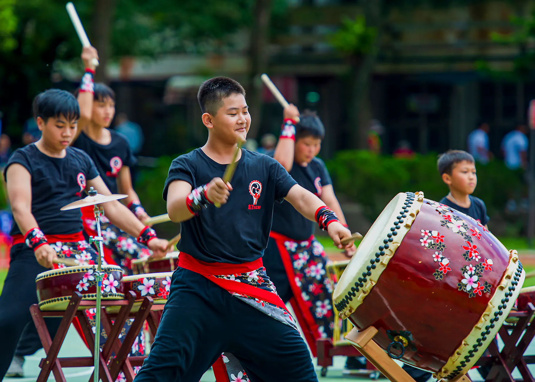 Exciting outdoor Taiko drumming performance in Taiwan featuring young musicians engaging the audience.