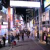 Bustling nightlife on Takeshita Street, Tokyo, showcasing vibrant neon signs and a lively crowd.
