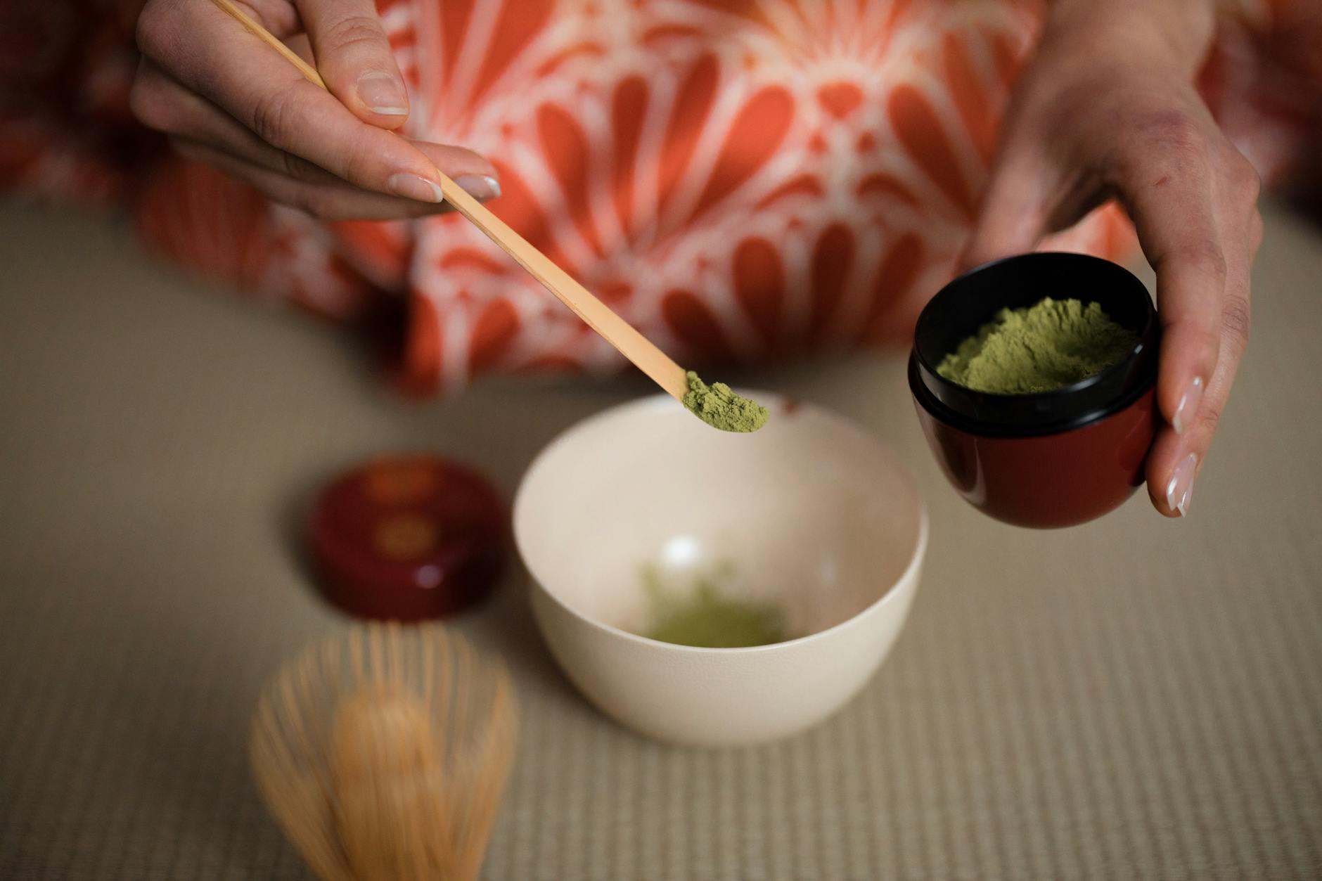 Woman preparing matcha in a traditional Japanese tea ceremony