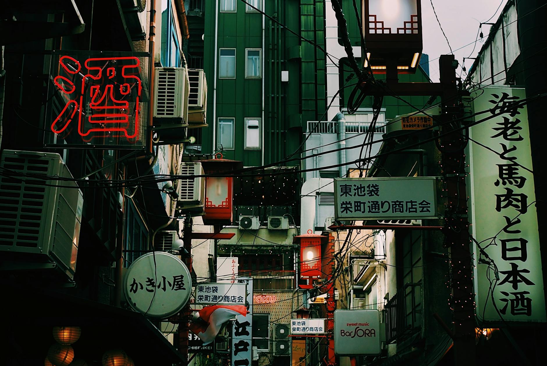 A bustling Tokyo street with neon signs and traditional architecture captures the vibrant nightlife in Japan's capital.