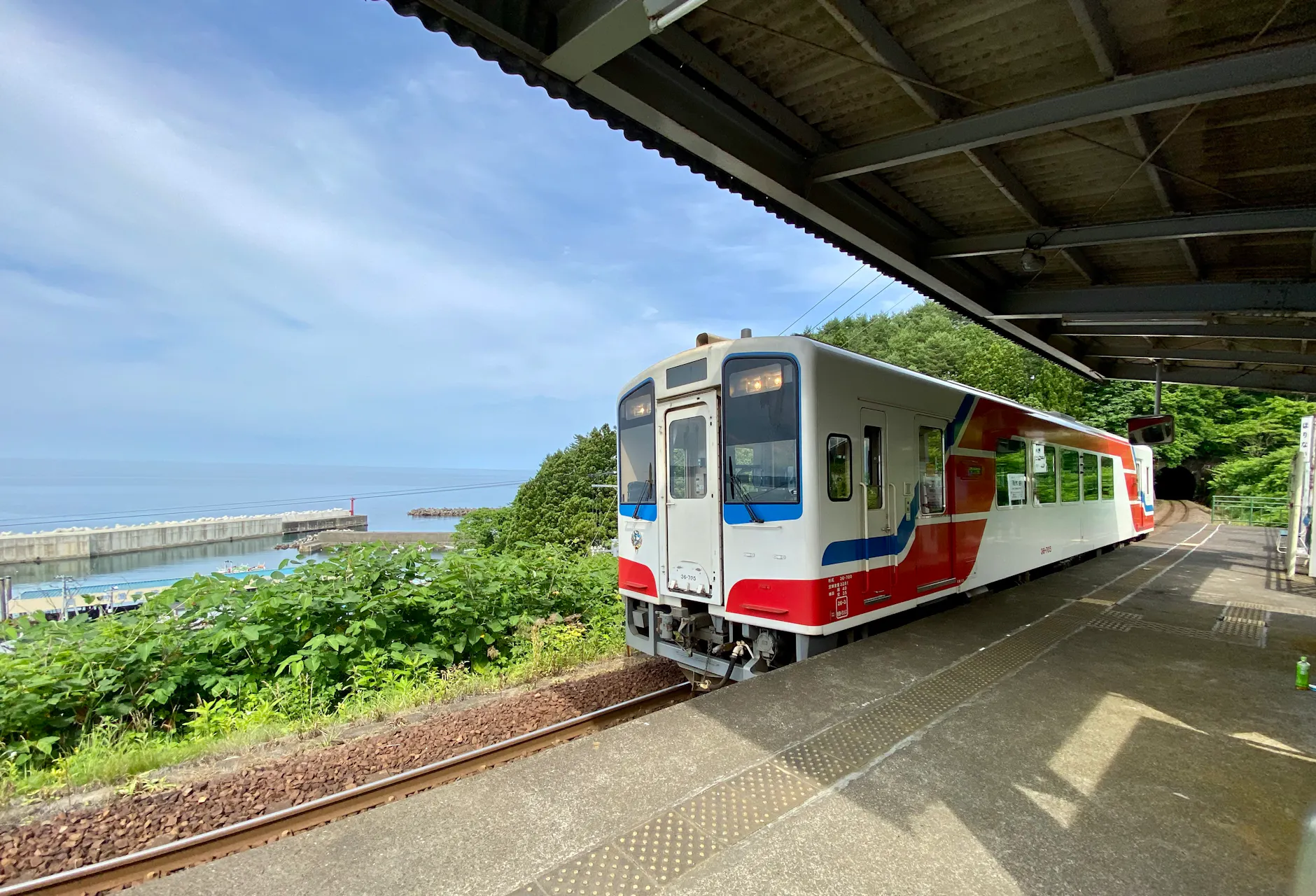 Colorful train at Fudai Station, Iwate, Japan with coastal view.