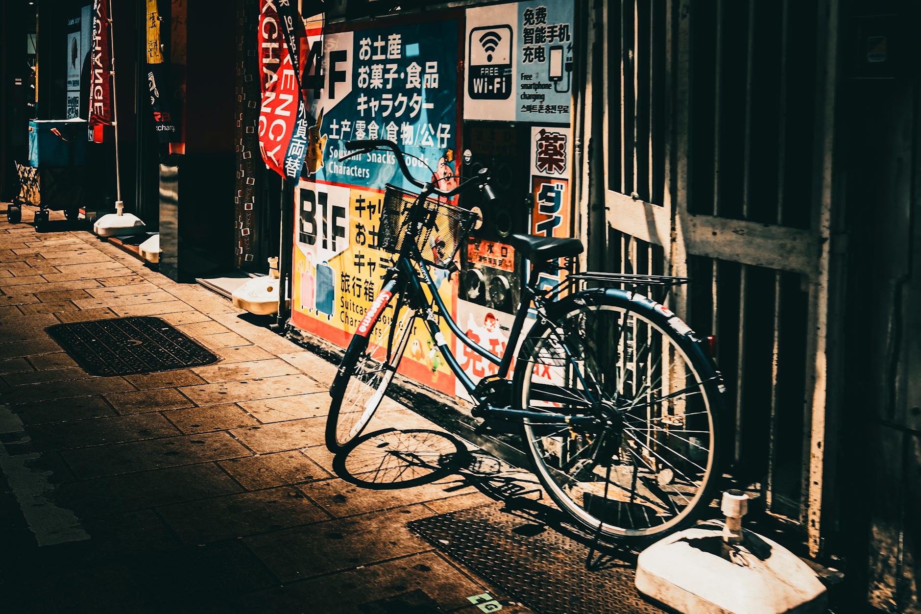 An artistic shot of a vintage bicycle leaned against a colorful urban wall in sunlight.