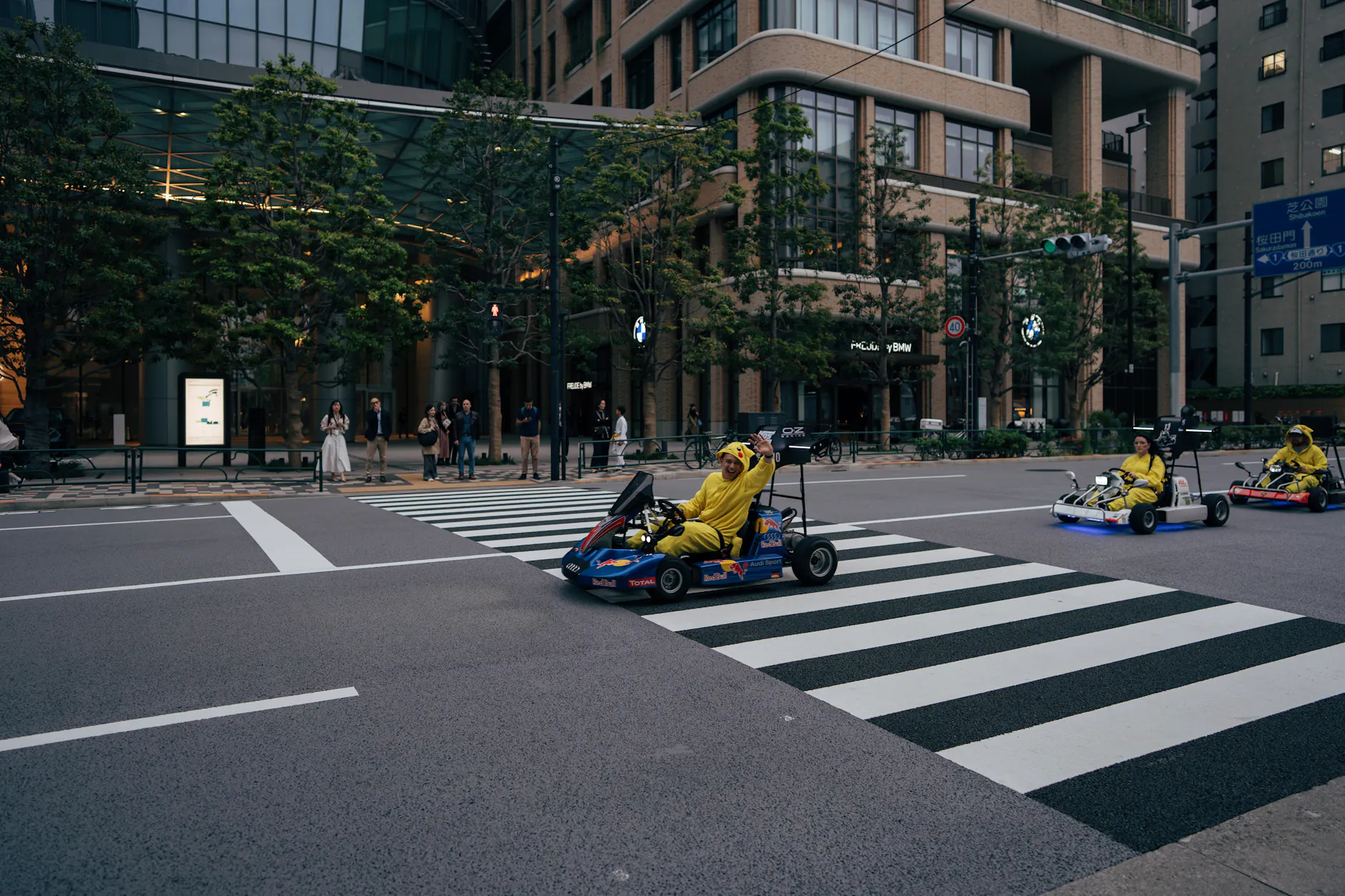 Colorful go-kart adventure on Tokyo streets with people in costumes. A fun and vibrant city experience.