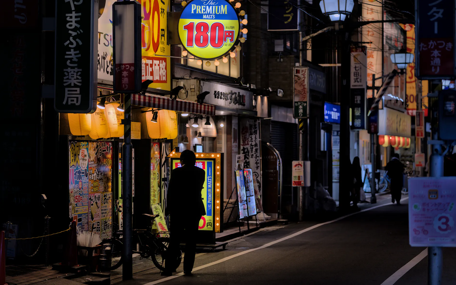 A vibrant street scene in Takatsuki, Osaka at night, capturing urban nightlife and neon lights.