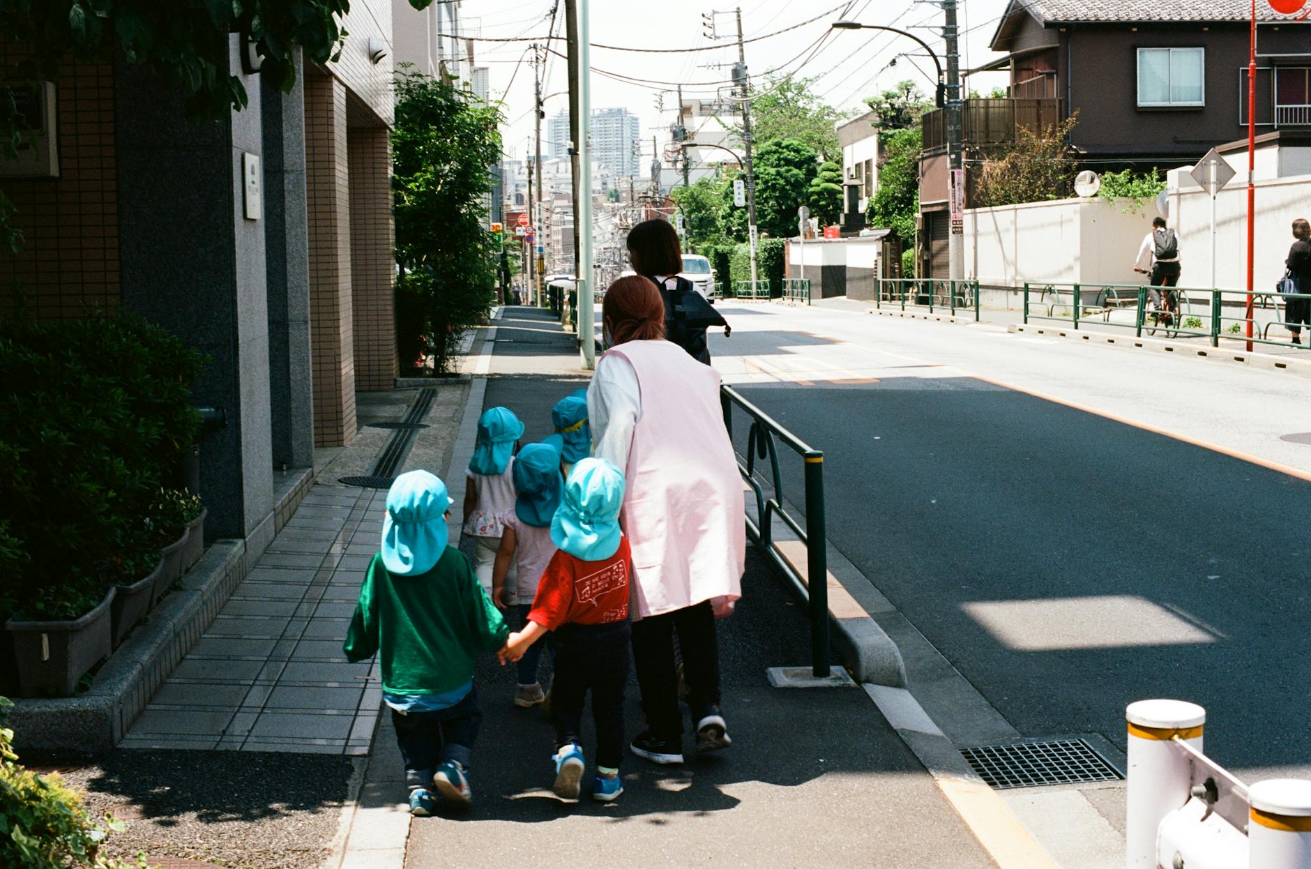 A group of children with a teacher walking in a Tokyo street, Japan.