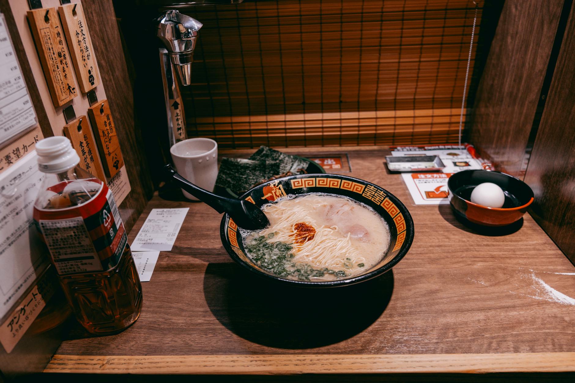 A steaming bowl of ramen served in a private dining booth in Tokyo, Japan.