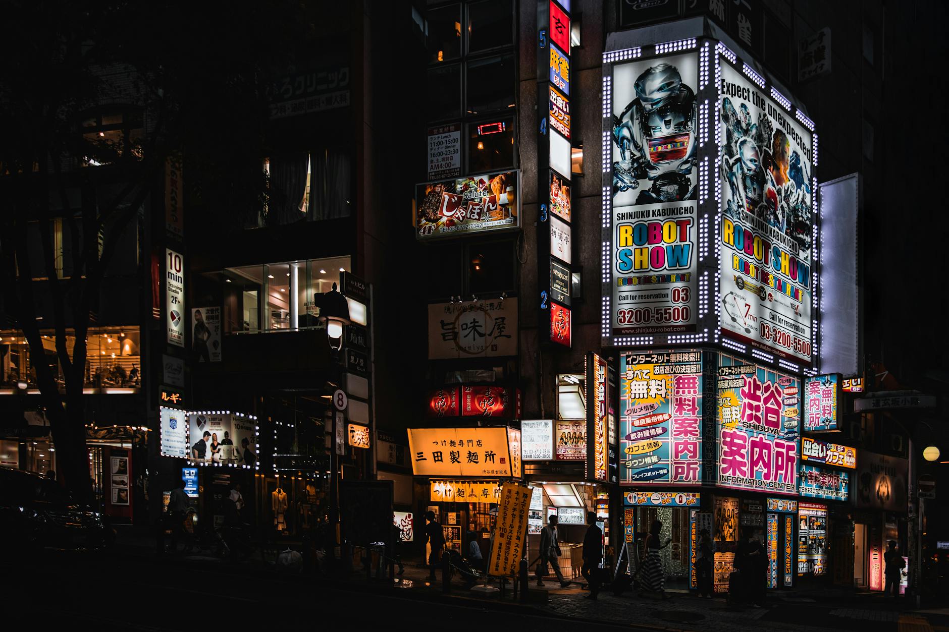 Bright neon signs illuminate the bustling streets of Shinjuku at night, capturing Tokyo's vibrant nightlife.