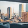 Captivating cityscape of Tokyo with Tokyo Tower framed by a hotel window, highlighting modern architecture.