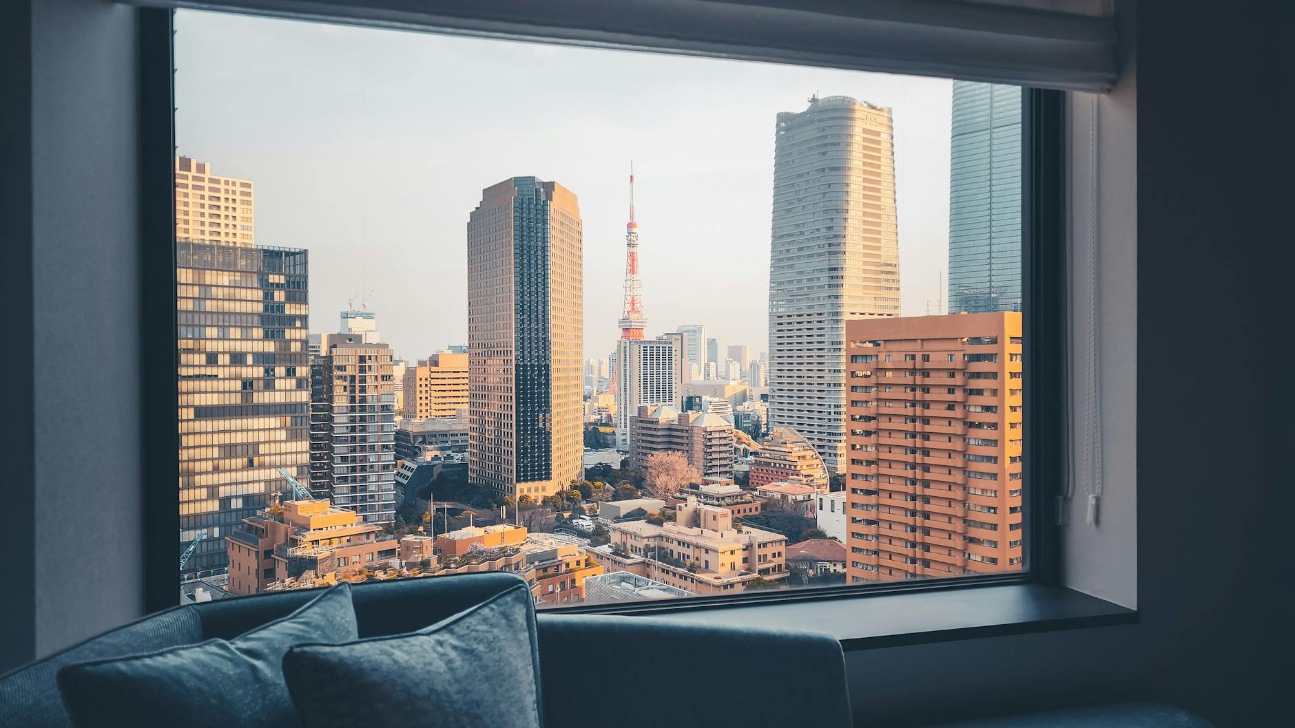 Captivating cityscape of Tokyo with Tokyo Tower framed by a hotel window, highlighting modern architecture.