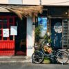 Colorful street scene in Yanaka Ginza, Tokyo with bicycle and vintage shop facade.