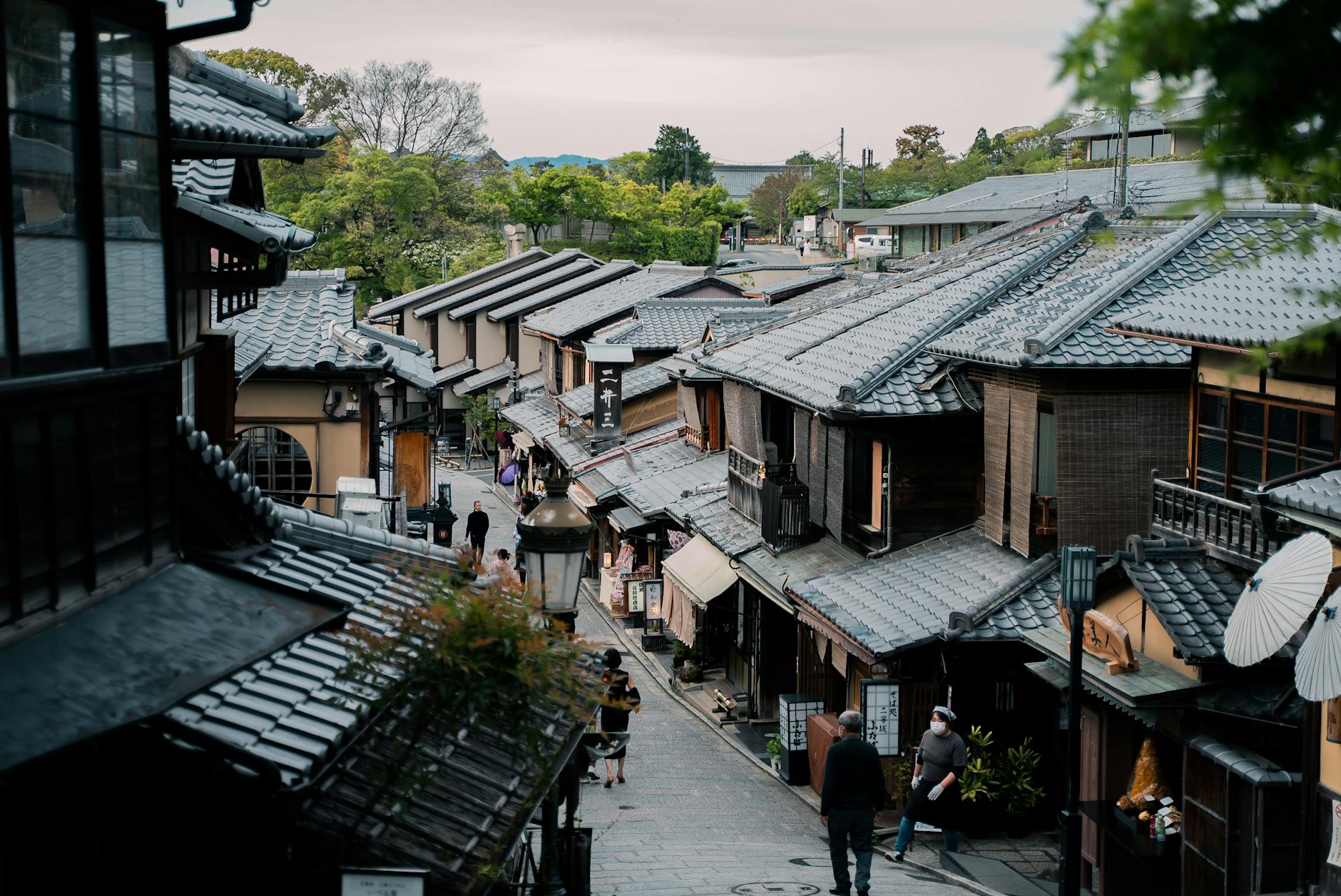 Explore the traditional architecture and serene streets of Kyoto's historic district, showcasing classic Japanese wooden houses.